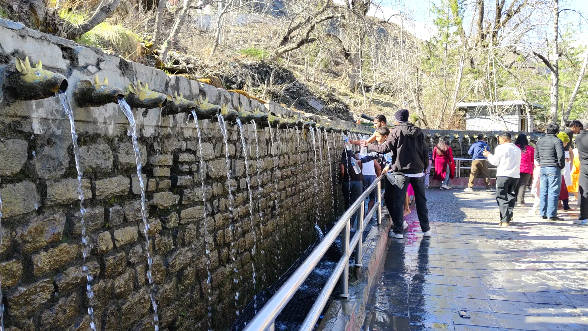 Visitors at Muktinath temple 108 water spouts with brass cow-head fixtures