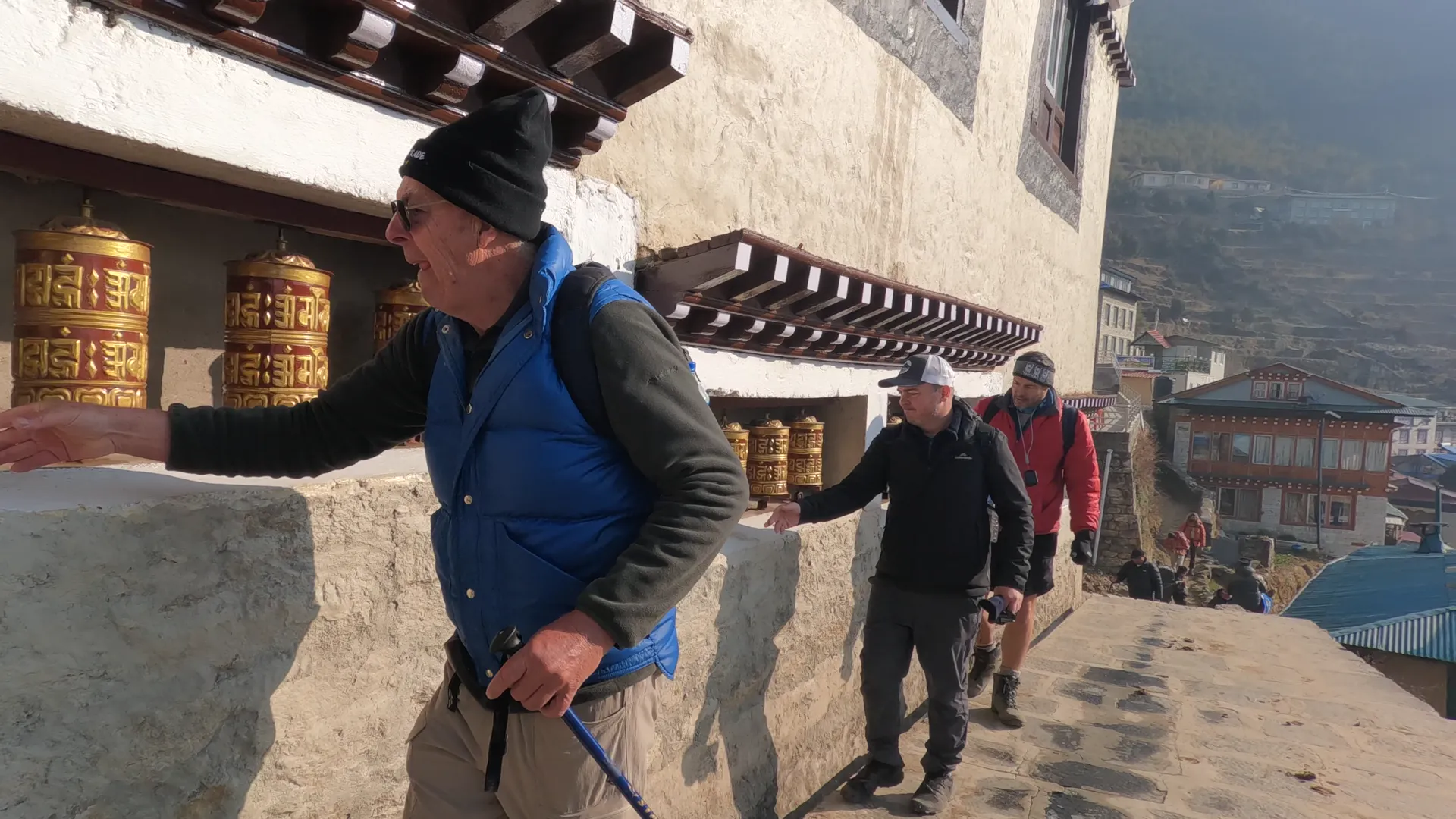 Trekkers spinning brass prayer wheels above Namche Bazaar