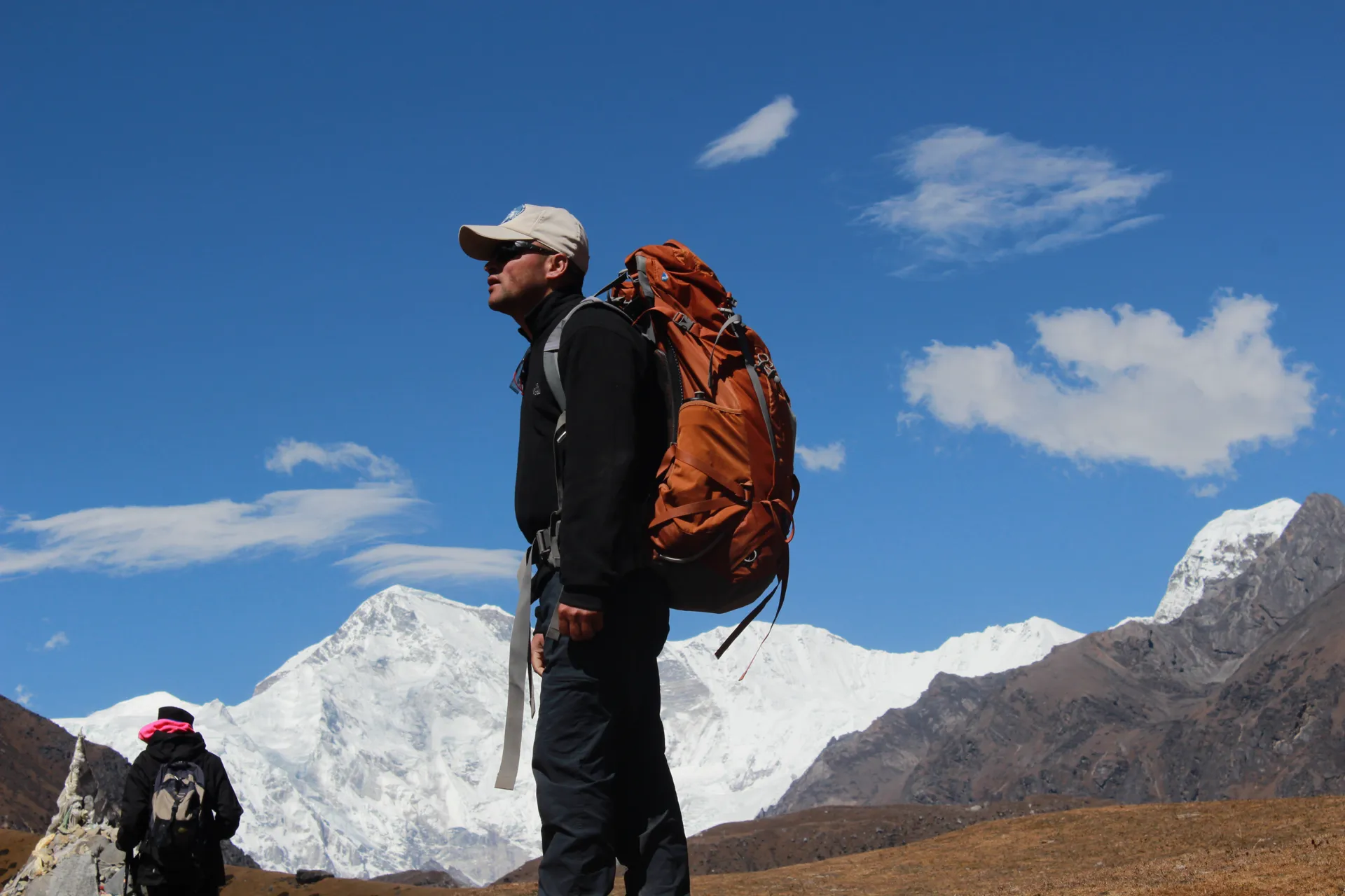 Guide in cap with orange backpack, Cho Oyu and Gyachung Kang behind