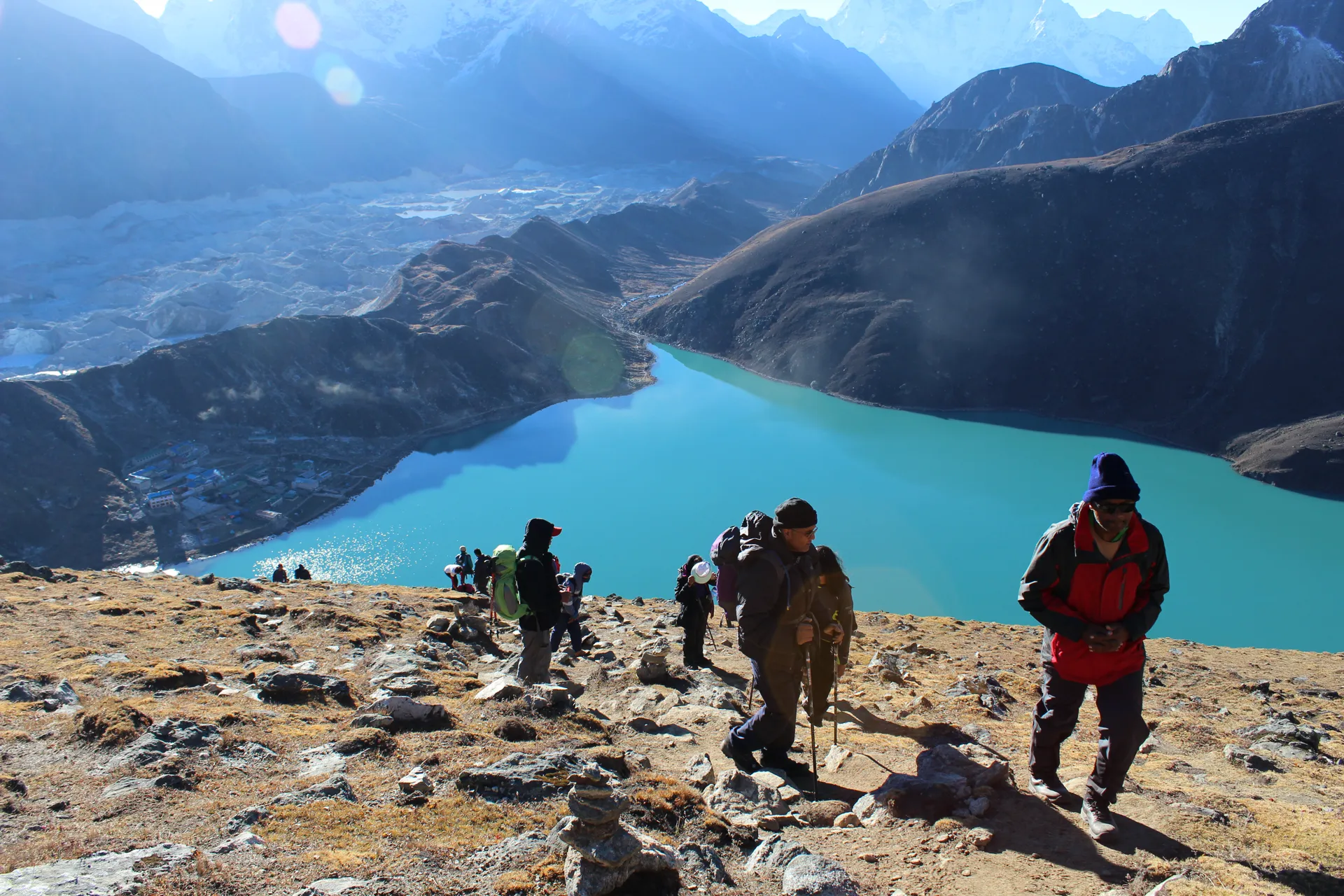 Trekkers ascending toward Gokyo Ri with Gokyo Lake glowing below