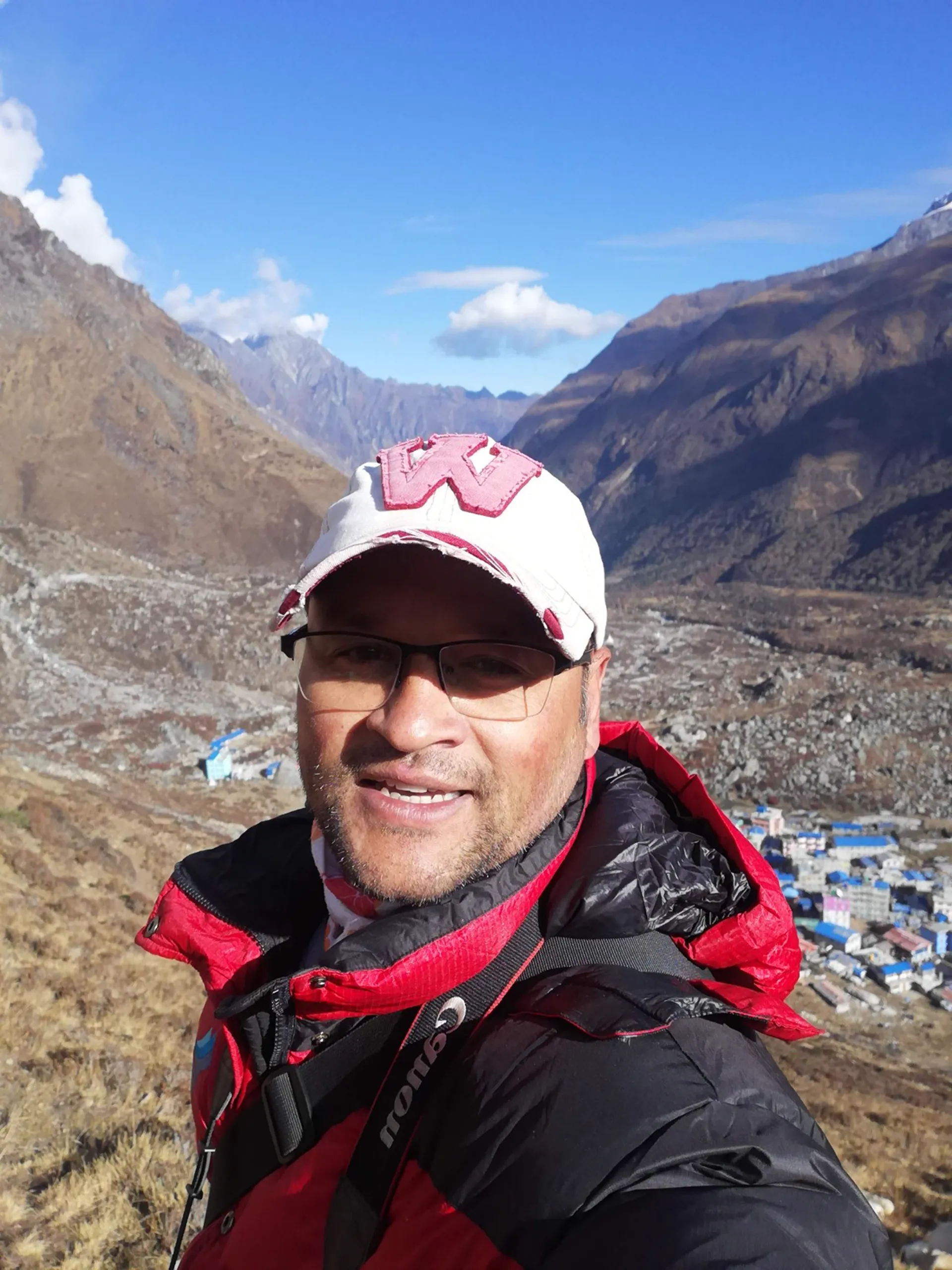 Guide taking a selfie above Langtang village with mountain valley behind