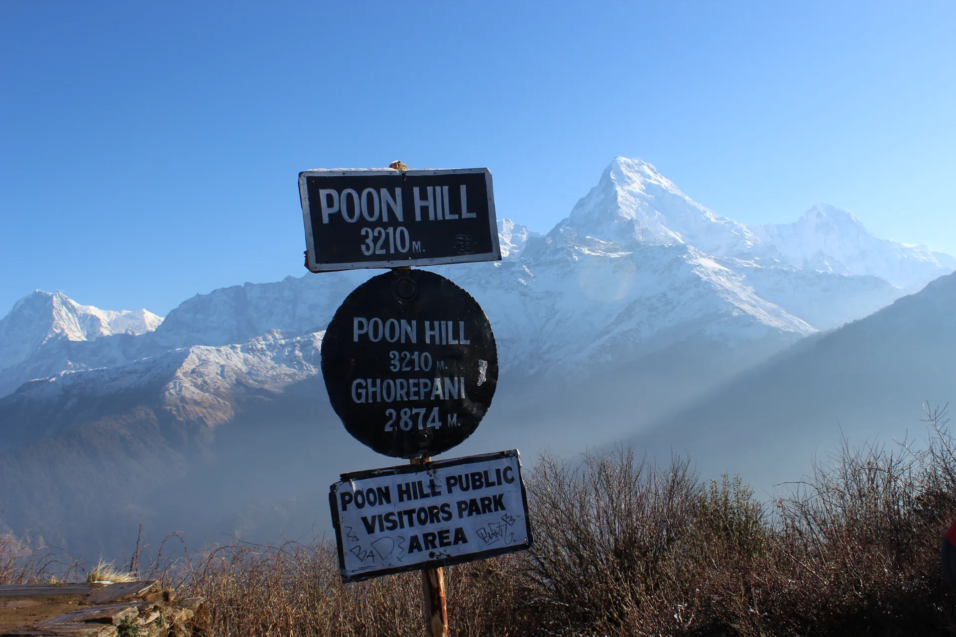 Poon Hill 3,210m altitude sign with Annapurna South peak in background