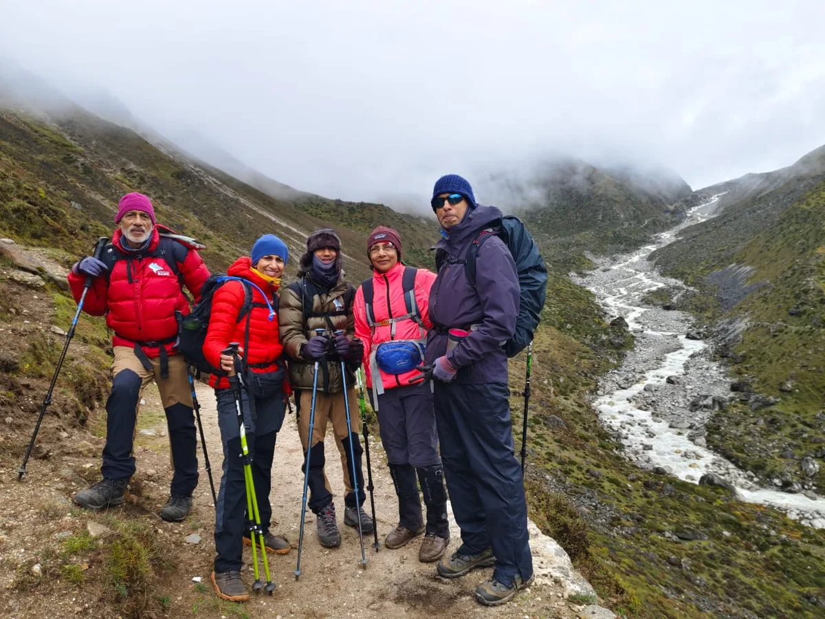Trekking group posing with river valley backdrop