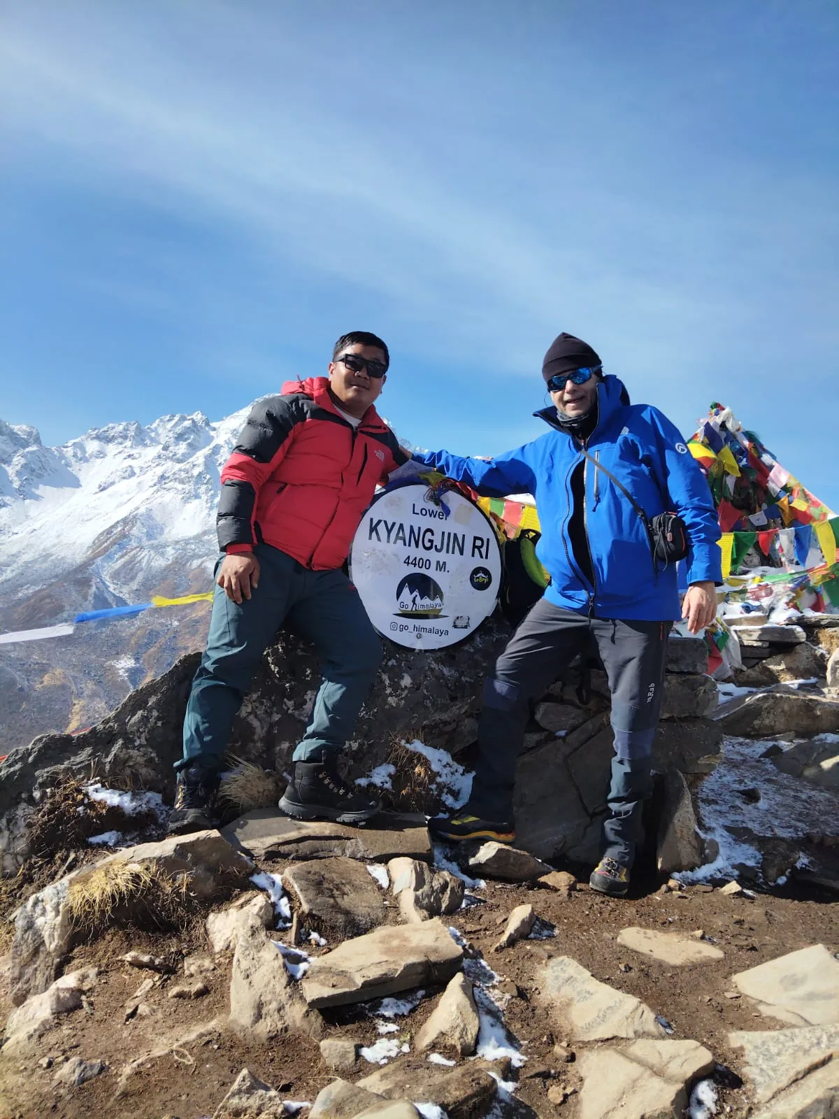Trekkers at Kyanjin Ri summit with prayer flags