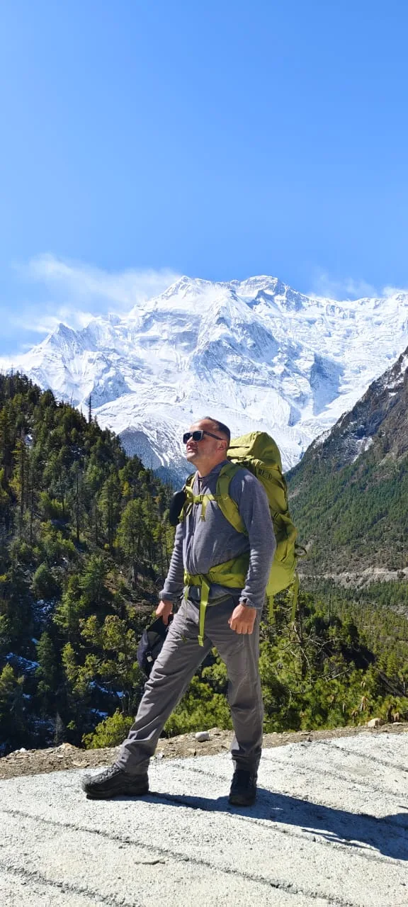 Solo trekker walking with Annapurna behind